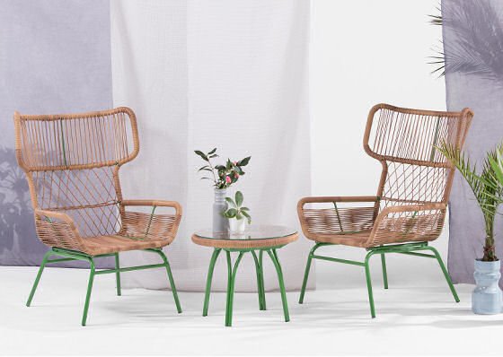 Rattan garden furniture with green frame, rattan armchairs and rattan side table in outdoor room