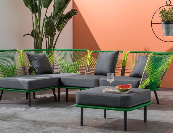 Colourful garden furniture in outdoor room with outdoor corner sofa and footstool