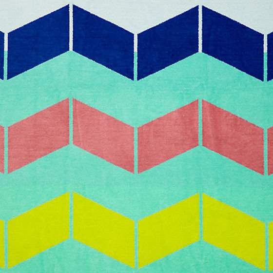 Details of brightly coloured beach towel with block colour chevrons