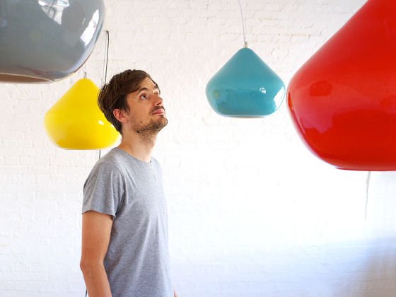 Brightly coloured pendant lights with man looking at them