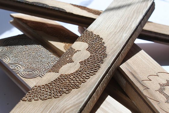 Lengths of wood with various lacy decorative designs laser cut into surface