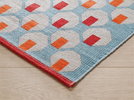 Cotton Octo Rug detail with orange, red, blue and green geometric shapdes and red border