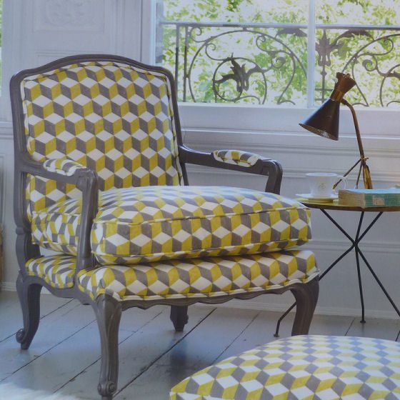 Andrew Martin chair covered in Balyan fabric Grey armchair covered in grey and yellow Balyan3D cube geometric fabric