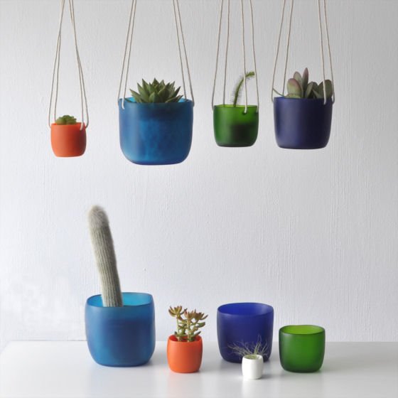 Colourful resin hanging planters and vessels with plants and succulents
