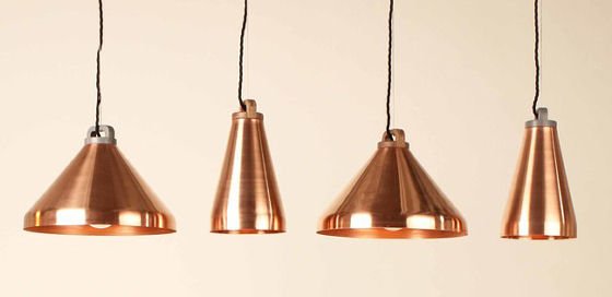Four spun copper pendant lights with walnut or Corian fittings