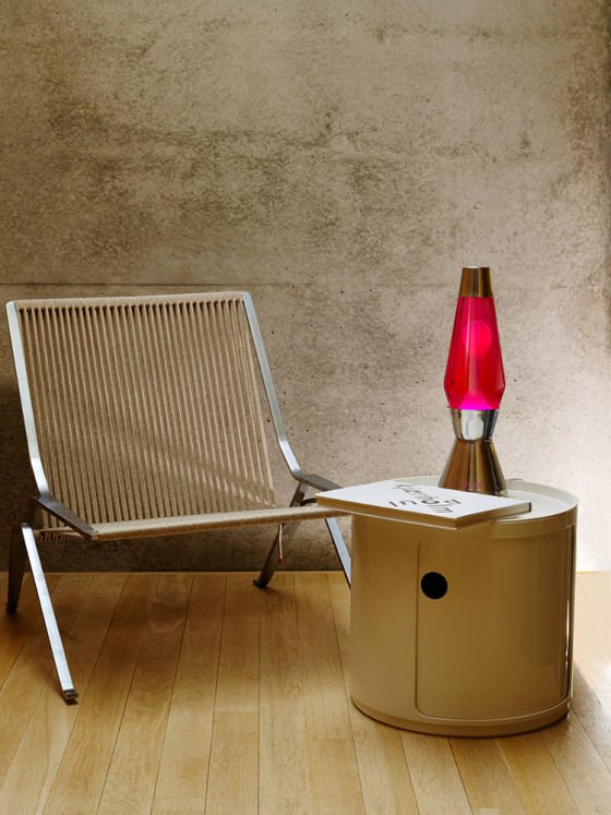 Red lava lamp Red lava lamp on table next to metal chair