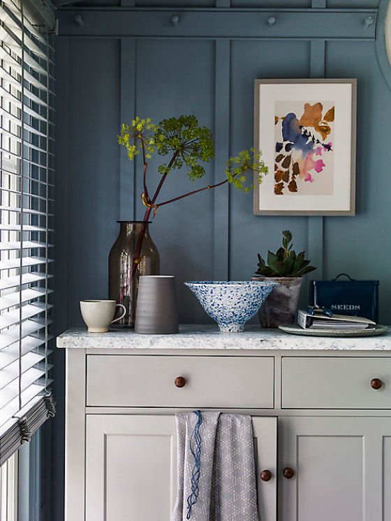 Croft Collection Montrose Sideboard with marble top against blue panelled wall with colourful painting