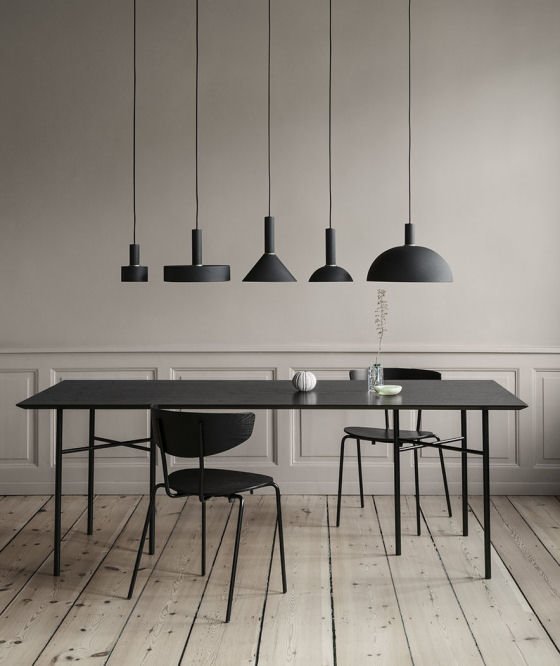 Ferm Living Collect Lighting black and brass contemporary pendant lights hung over black dining table