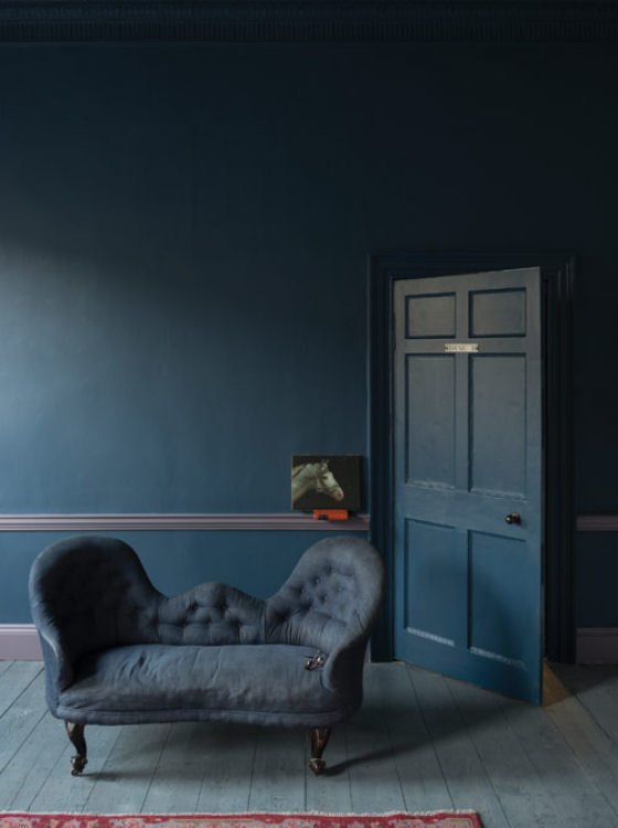 Stiffkey Blue Wall painted in Farrow and Ball paint Stiffkey Blue with blue sofa