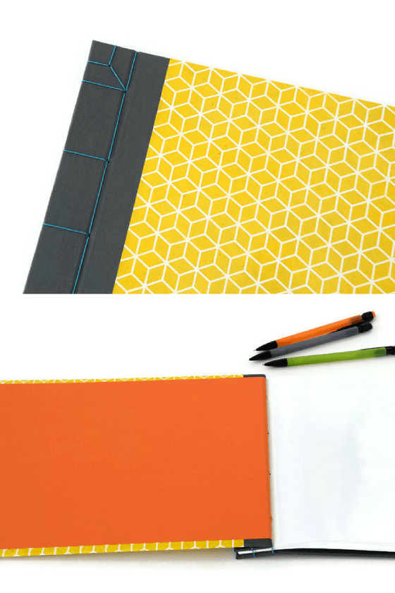 Detail of handmade journals with grey bookcloth, yellow lokta paper and blue linen stab binding