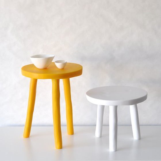 Yellow and white resin tables or stools with white vessels on yellow tall stool
