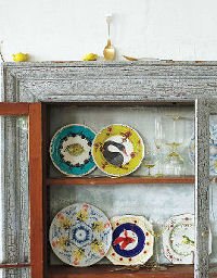 Anthropologie display Colourful tableware in cupboard