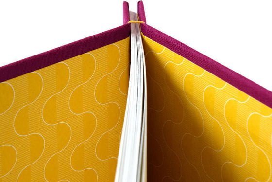 Detail of stab bound handmade journal showing yellow patterned lining papers