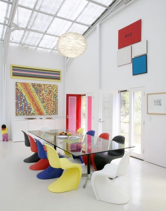 Eos feather pendant lamp hung in white contemporary room with glass table and coloured Panton chairs