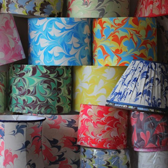 Brightly coloured marbled silk lampshades arranged in pile
