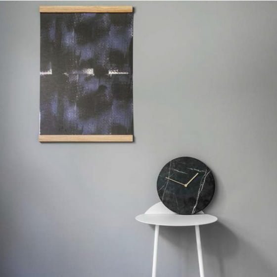 Black Marble Wall Clock by Menu on white table against grey wall with abstract print