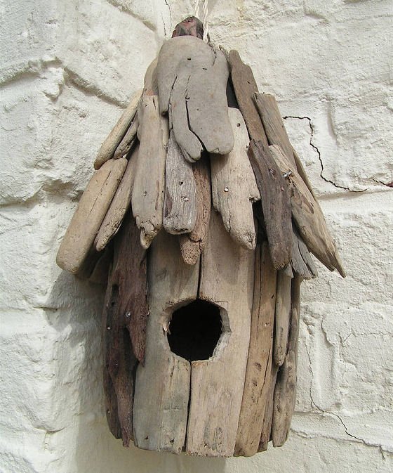 Driftwood birdhouse against white wall