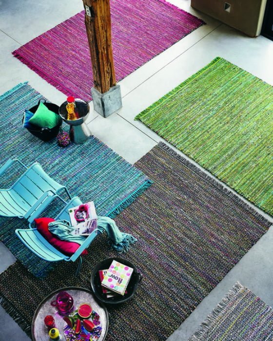 Aerial shot of colourful rugs in room with chairs and table