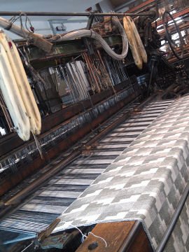 Grey and white Eleanor Pritchard blanket being woven on loom
