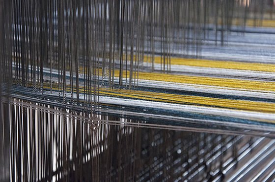 White, grey and yellow wool on loom