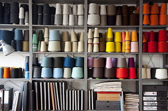 Coloured spools of wool on shelves in studio