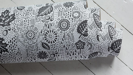 Close up of roll of modern wallpaper with grey design on white